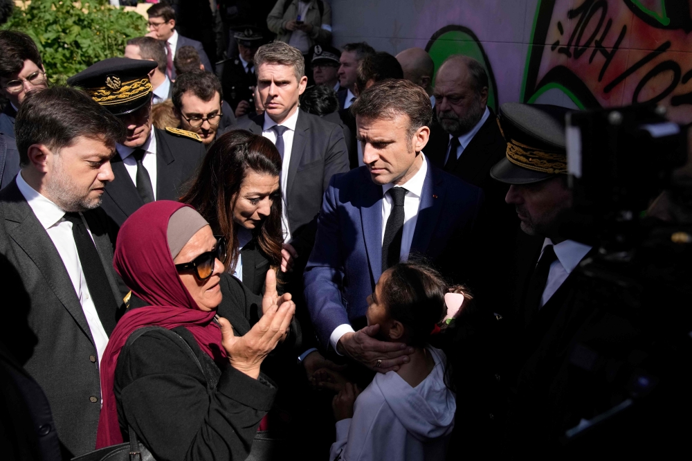 French President Emmanuel Macron (centre) meets with residents during a visit focusing on security and the fight against drug trafficking, in La Castellane district of Marseille, southeastern France, on March 19, 2024. — AFP pool pic