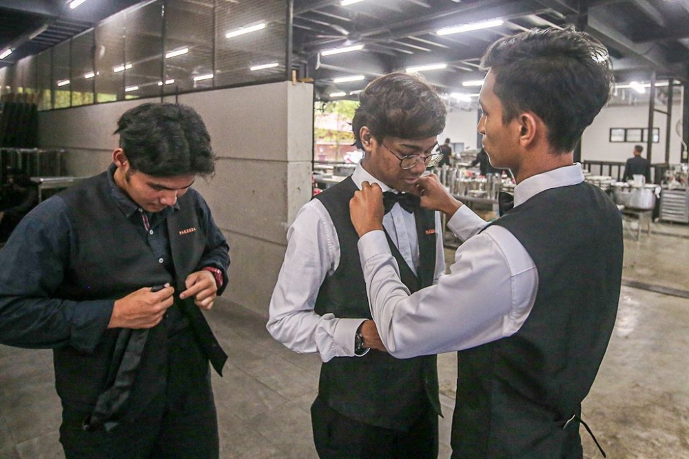 Banquet waiters getting dressed up to serve the dinner guests.