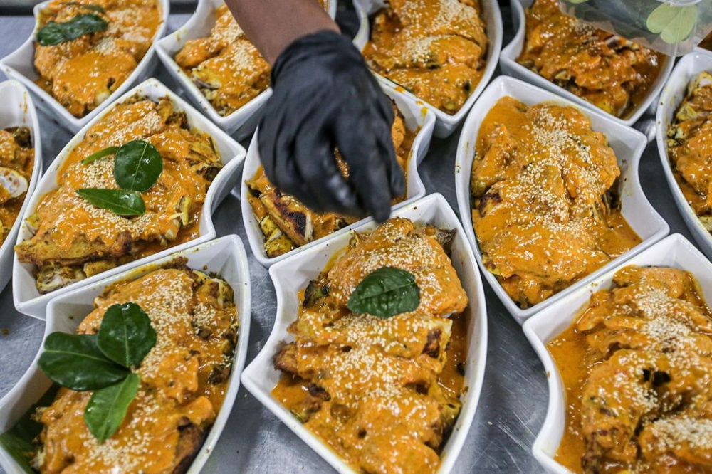 A kitchen worker putting the finishing touch to a dish.