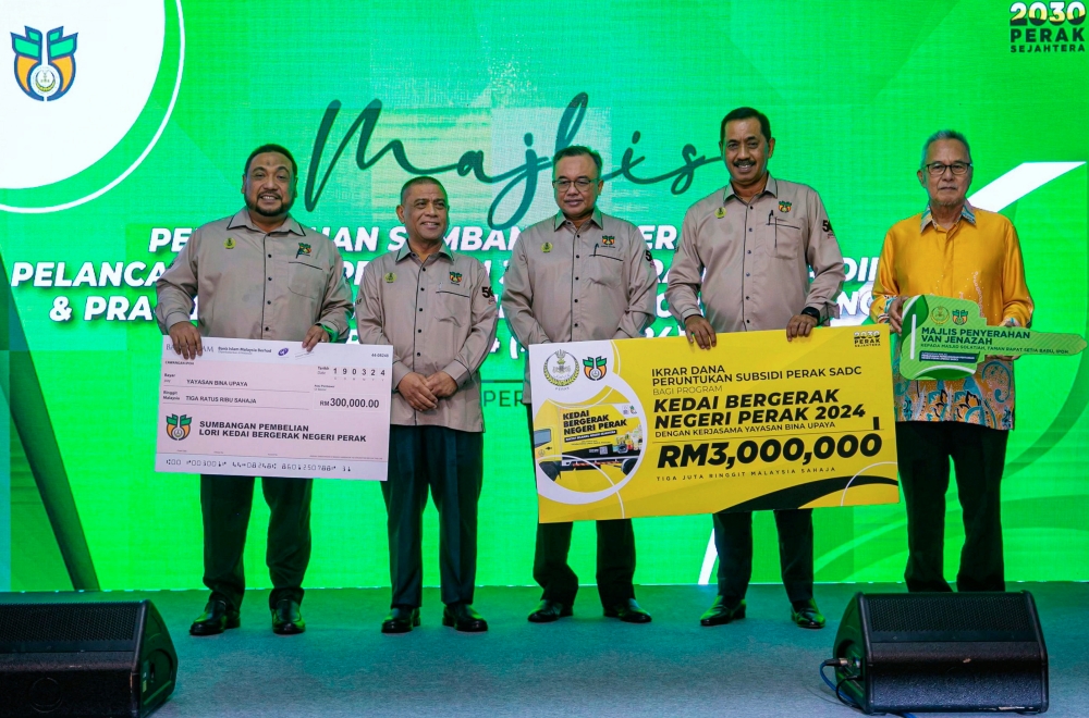Perak Menteri Besar Datuk Seri Saarani Mohamad (2nd left) poses with recipients of aid from the Perak State Agriculture Development Corporation in Ipoh March 19, 2024. — Bernama pic