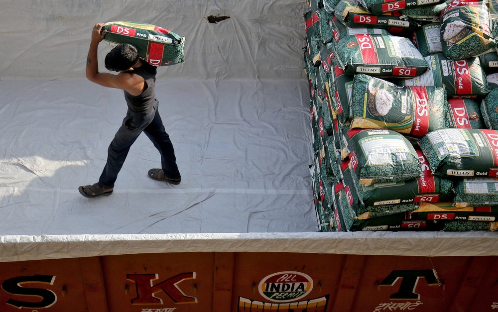 A labourer unloads a sack of rice from a supply truck at a wholesale market in Ahmedabad October 15, 2018. The retail prices of imported white rice (BPI) will be reduced between RM2 and RM3 effective tomorrow, according to the Ministry of Agriculture and Food Security. — Reuters pic