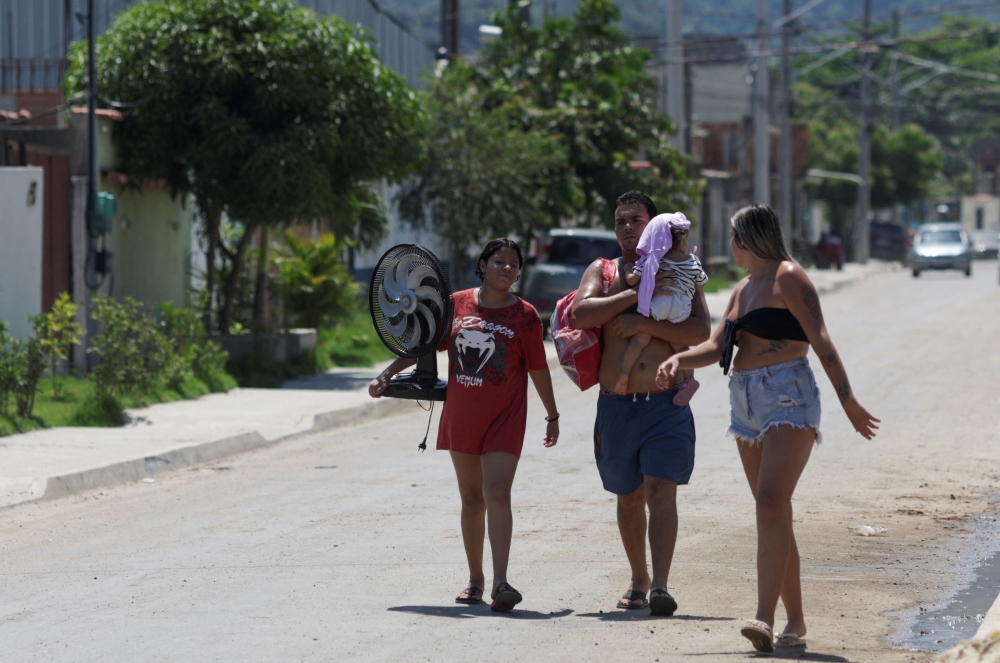 Residents walk on a street of Guaratiba neighbourhood, amid a heatwave in Rio de Janeiro, Brazil, March 17, 2024.  — Reuters pic