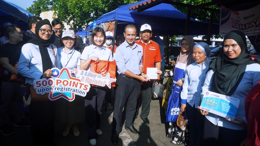 Kedah KPDN director Muhammad Nizam Jamaludin (5th right) hands gifts to traders during the opening the Bazaar Ramadan Rahmah Programme in Pendang March 19, 2024. — Bernama pic