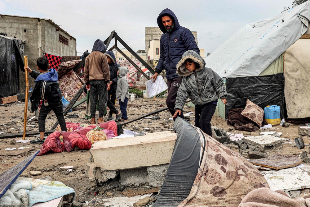 Displaced Palestinians inspect the damage to their tents following overnight Israeli bombardment at a Rafah camp. — AFP pic