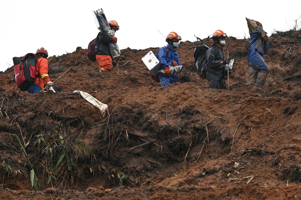This file photo taken on March 24, 2022 shows rescue workers combing through the site of where China Eastern flight MU5375 crashed on March 21, near Wuzhou in southwestern China’s Guangxi province. The second black box has been recovered from a crashed China Eastern passenger plane, state media reported on March 27, 2022. — AFP pic