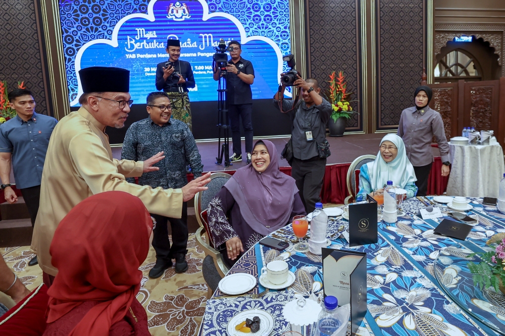 Prime Minister Datuk Seri Anwar Ibrahim and his wife Datuk Seri Dr Wan Azizah Wan Ismail (seated, right) together with Bernama CEO Nur-ul Afida Kamaludin (seated, centre) are seen during the Madani Buka Puasa event with media practitioners at Seri Perdana Complex March 20, 2024. — Bernama pic