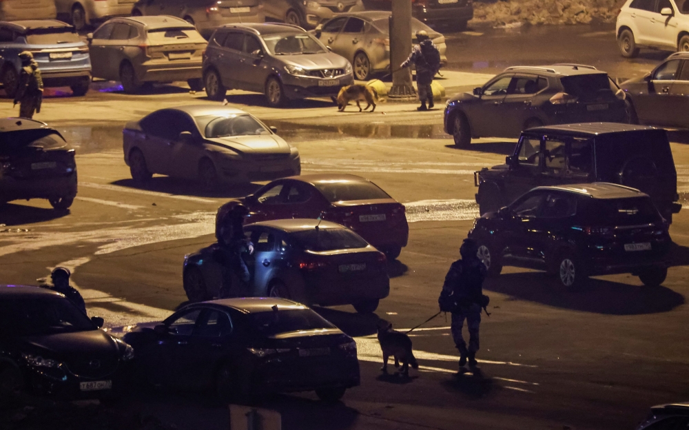 Law enforcement officers search near the burning Crocus City Hall concert venue following a shooting incident, outside Moscow, Russia March 22, 2024. ― Reuters pic