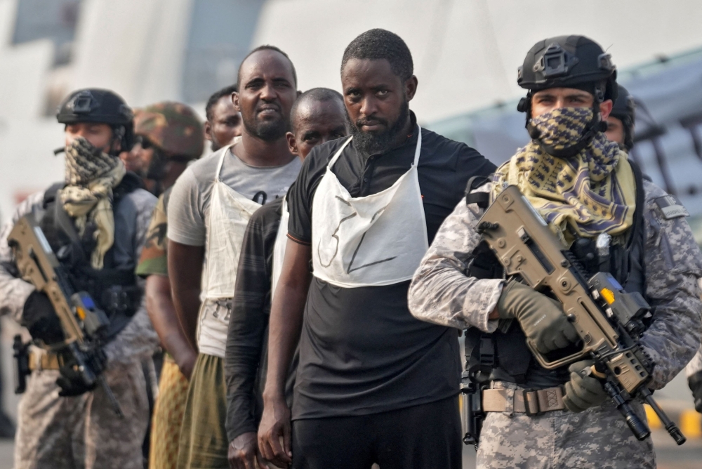 An Indian soldier stands guard next to captured Somali pirates after they were brought in for prosecution by the Indian Navy, at the Naval Dockyard in Mumbai, India, March 23, 2024. — Reuters pic