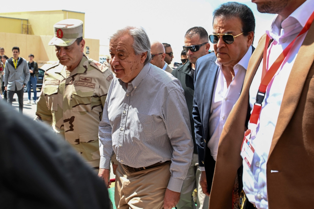 UN Secretary-General Antonio Guterres (centre) walks on the tarmac flanked by the Egyptian Second Army in Sinai Chief Mohammad Abdel Rahman (left) and Egypt's Health Minister Khaled Abdel Ghaffar (right), upon landing at Egypt's al-Arish Airport, near the Rafah border with the Gaza Strip on March 23, 2024, amid ongoing battles between Israel and the Palestinian militant group Hamas. — AFP pic