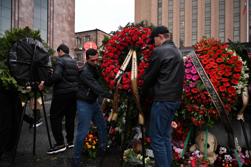 People lay flowers at a makeshift memorial in front of the Russian embassy in Yerevan on March 23, 2024, a day after a gun attack on the Crocus City Hall in Russia’s Krasnogorsk. — AFP pic