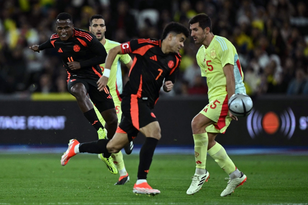 Colombia’s midfielder #11 Jhon Arias (left) has a shot on goal blocked by Spain’s defender #05 Robin Le Normand during the international friendly football match between Spain and Colombia at The London Stadium in east London on March 22, 2024. — AFP pic