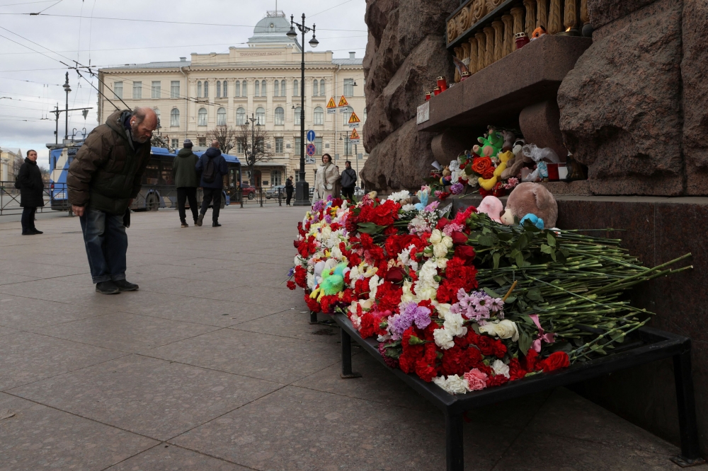 A man bows next to a makeshift memorial to the victims of a shooting attack at the Crocus City Hall concert venue in the Moscow Region, in Saint Petersburg, Russia March 24, 2024. — Reuters pic