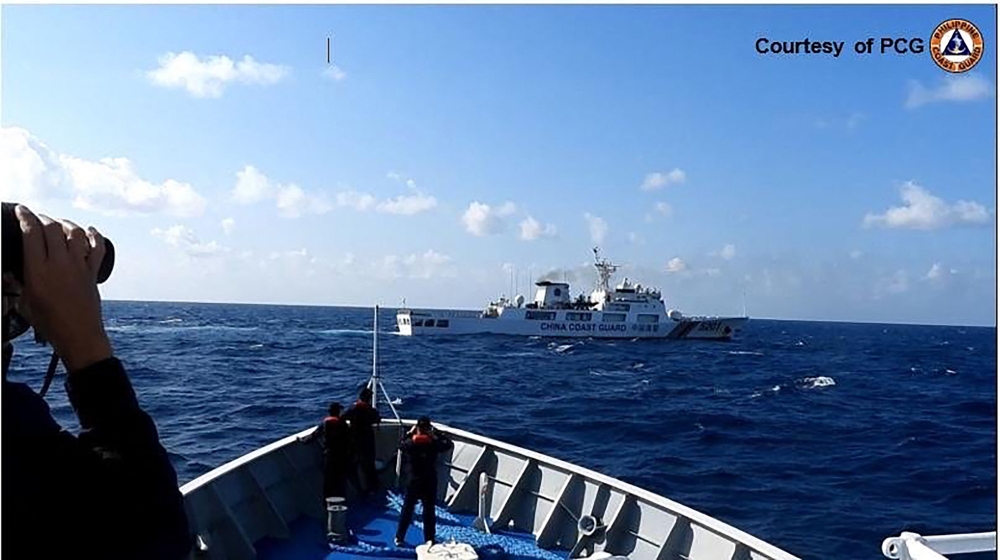 A Chinese Coast Guard ship (top) manoeuvering past a Philippine Coast Guard ship near Sandy Cay reef, near the Philippine-held Thitu Island in Spratly Islands. — AFP pic/Philippine Coast Guard (PCG)