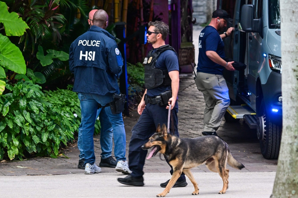 Federal and Homeland Security Investigation agents are seen at the entrance of US producer and musician Puff Daddy’s home at Star Island in Miami Beach. — AFP pic