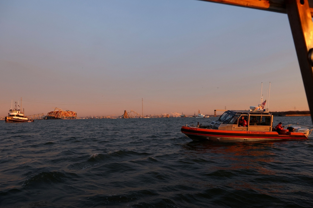 A US Coast Guard vessel secures the perimeter, after the Dali cargo vessel crashed into the Francis Scott Key Bridge causing it to collapse in Baltimore, Maryland March 26, 2024.  — Reuters pic
