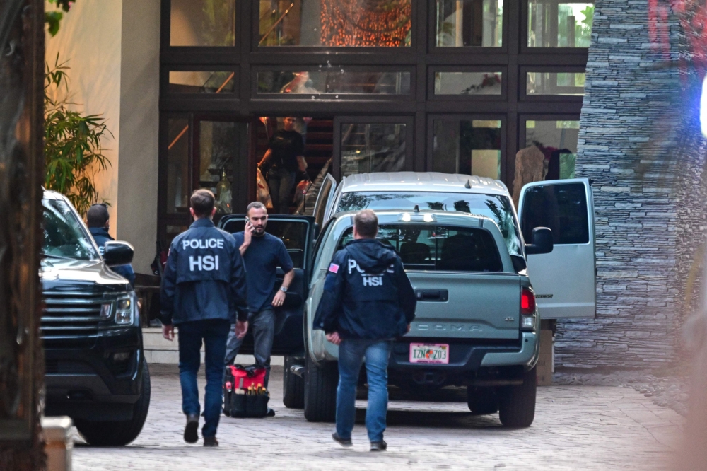 Homeland Security Investigation agents are seen at the entrance of US producer and musician Sean ‘Diddy’ Combs’s home at Star Island in Miami Beach. — AFP pic