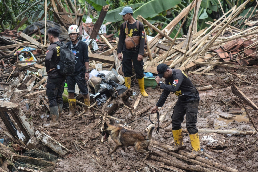 Rescuers search for survivors after a landslide and flooding hit a village on Java island. — AFP pic