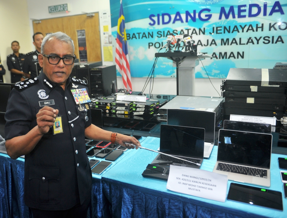 Bukit Aman Commercial Crime Investigation Department director Datuk Seri Ramli Mohamed Yoosuf shows laptops and other equipment seized at a press conference at Menara KPJ in Kuala Lumpur March 27, 2024. — Bernama pic