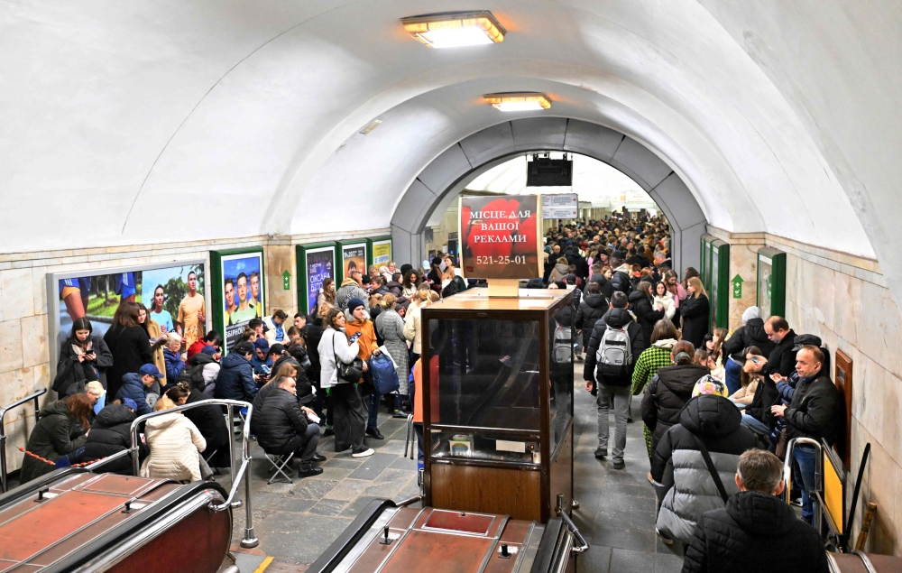People shelter in an underground metro station during an air raid alarm in Kyiv on March 25, 2024, amid the Russian invasion of Ukraine. — AFP pic