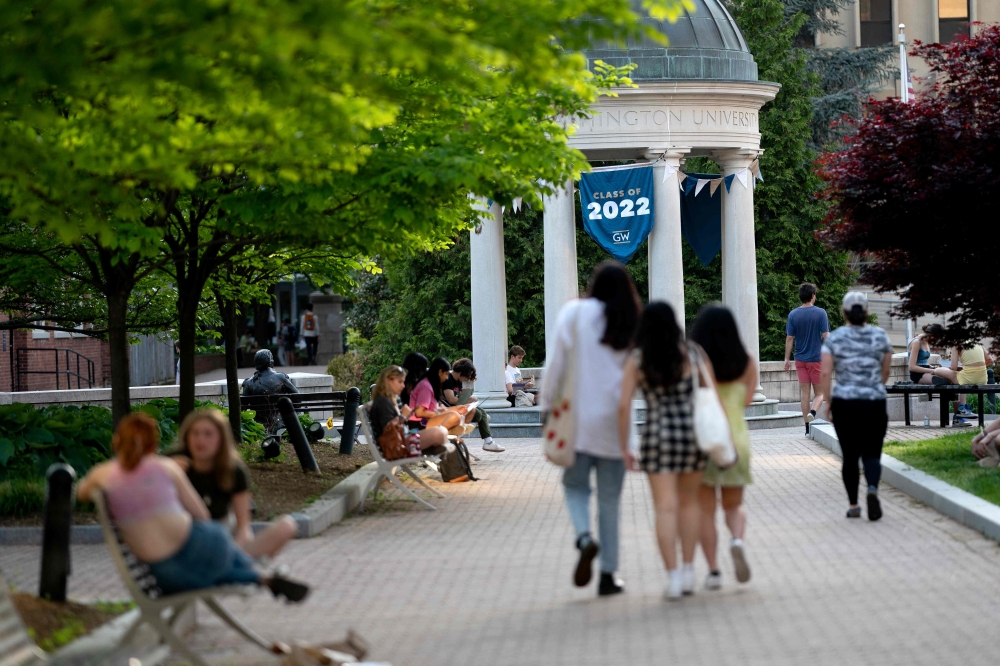 A 'Class of 2022' banner is displayed as students walk on campus at George Washington University in Washington, DC, on May 2, 2022. — AFP pic