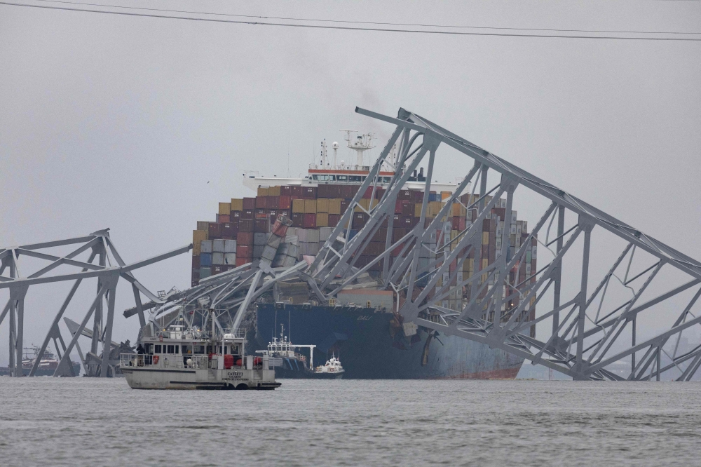 Workers continue to investigate and search for victims after the cargo ship Dali collided with the Francis Scott Key Bridge causing it to collapse yesterday, on March 27, 2024 in Baltimore, Maryland. — AFP pic