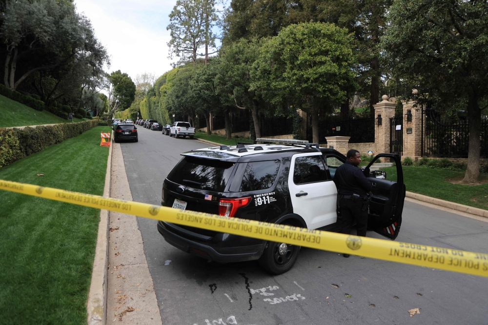 Police cars are seen behind caution tape outside the home of US producer and musician Sean 