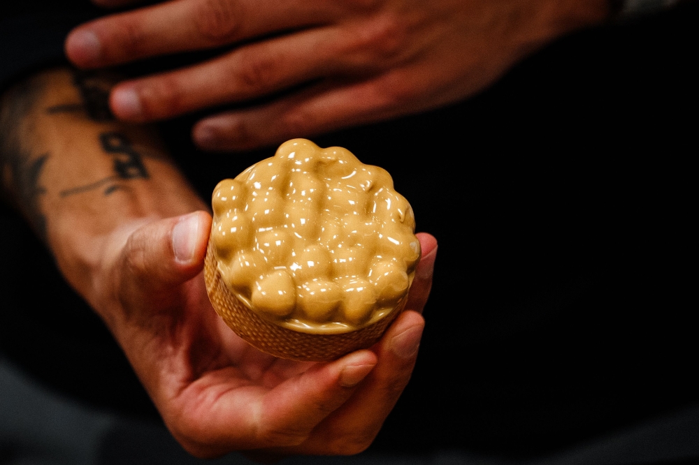 Pastry chef from Nice Philippe Tayac prepares tartelettes with hazelnuts and 'blond' chocolate at Valrhona chocolatier in Paris on March 1, 2024. — AFP pic
