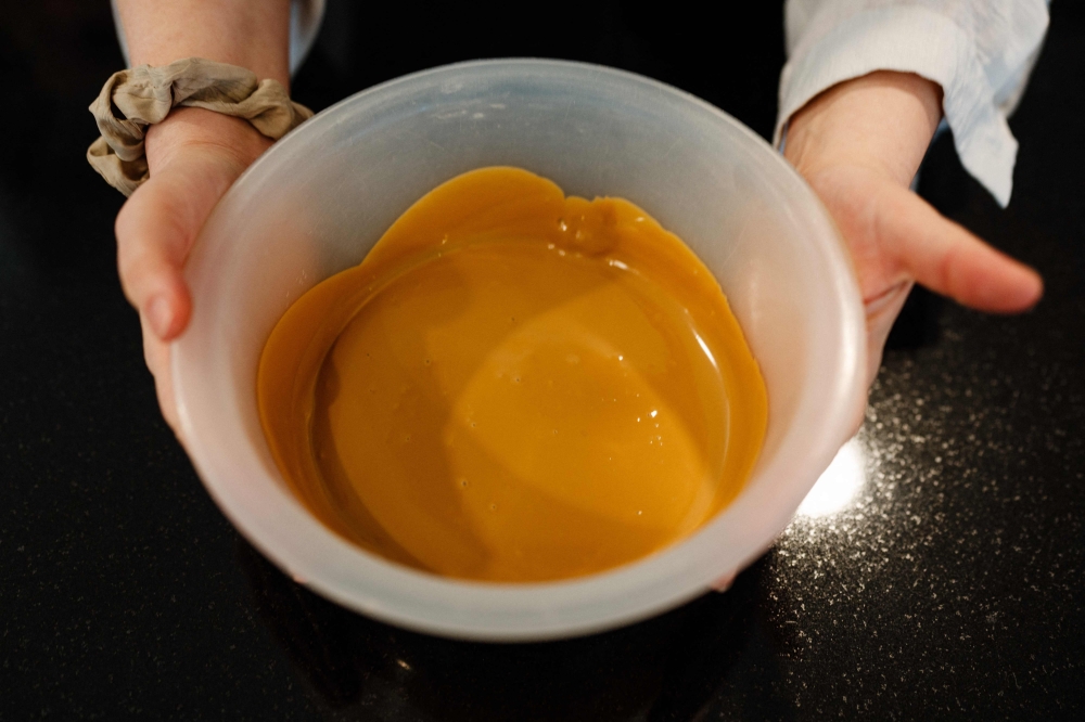French pastry chef and creative director of Valrhona chocolaterie Frederic Bau prepares a 'blond' chocolate at Valrhona chocolatier in Paris on March 1, 2024. — AFP pic
