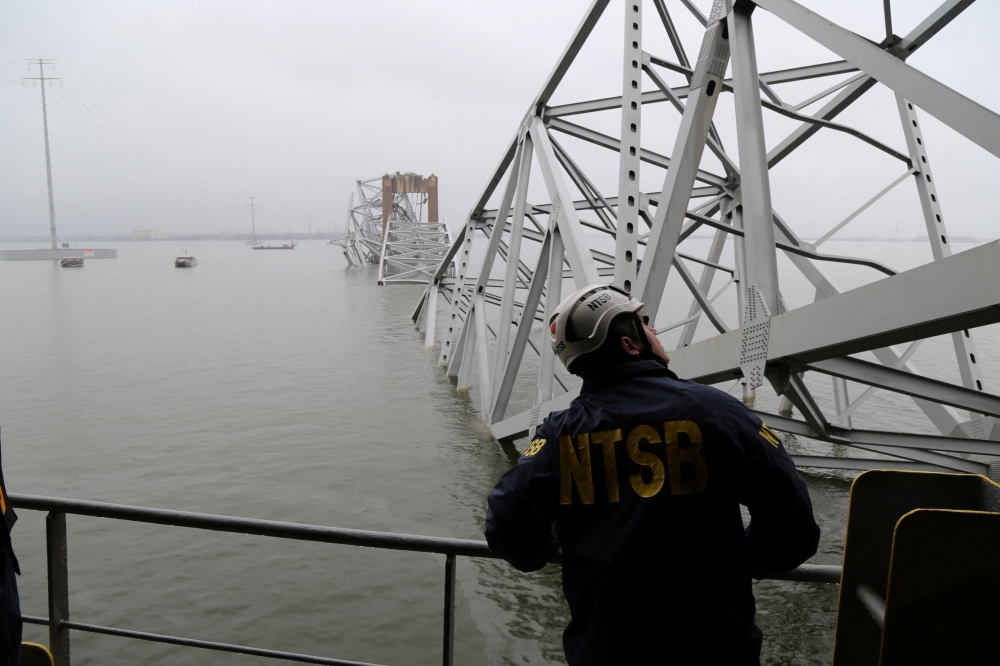 A National Transportation Safety Board (NTSB) worker looks on at the cargo vessel Dali, which struck and collapsed the Francis Scott Key Bridge, in Baltimore, Maryland March 27, 2024. — NTSB handout via Reuters