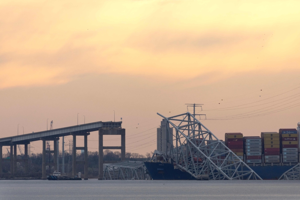 The sun descends beyond the collapsed Francis Scott Key Bridge on March 28, 2024 in Baltimore, Maryland. — Scott Olson/Getty Images/AFP pic