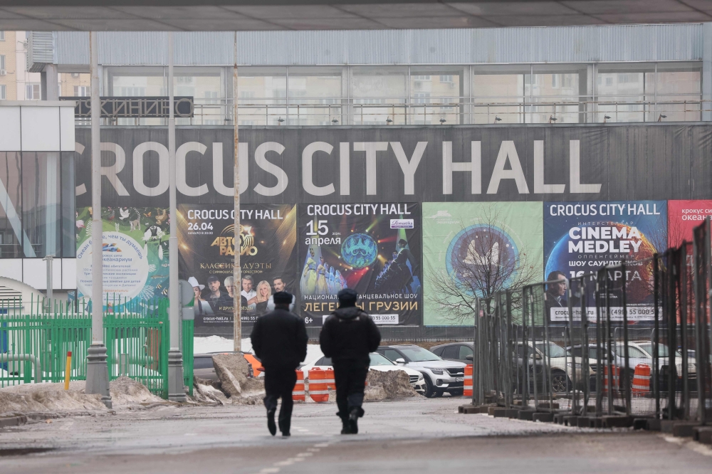 Russian law enforcement officers walk at the site of a gun attack on the Crocus City Hall in Krasnogorsk, outside Moscow, on March 23, 2024. — AFP pic