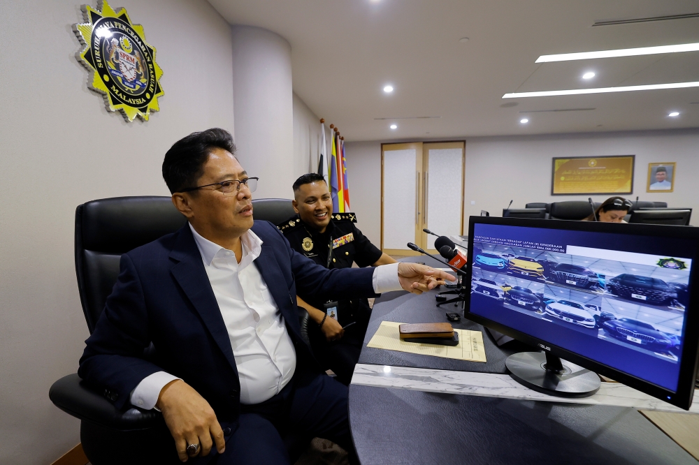 MACC chief commissioner Tan Sri Azam Baki points to seized cars during a special press conference on Ops Samba 2.0 —  smuggling activities of a syndicate which involved members of the Royal Malaysian Customs Department at the Kuala Lumpur International Airport (KLIA) Cargo in Sepang Cargo — at MACC headquarters in Putrajaya, March 29, 2024. — Bernama pic  