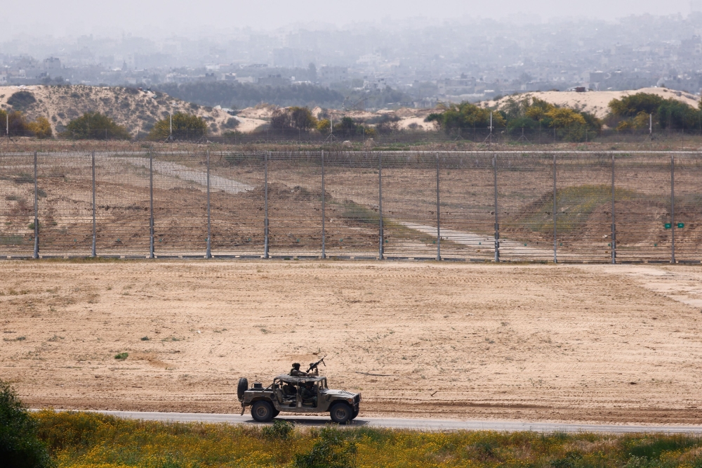 Israeli soldiers ride in a military jeep along the Israel-Gaza border, amid the ongoing conflict between Israel and the Palestinian Islamist group Hamas March 28, 2024. — Reuters pic  