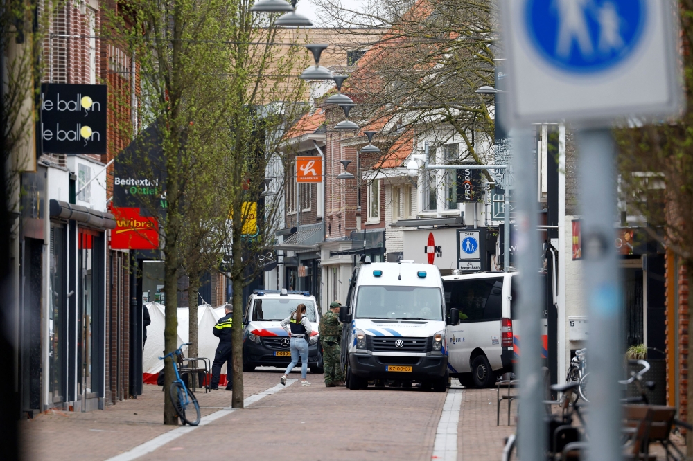 Dutch police officers work near the Cafe Petticoat, where several people are being held hostage in Ede, Netherlands March 30, 2024. — Reuters pic  