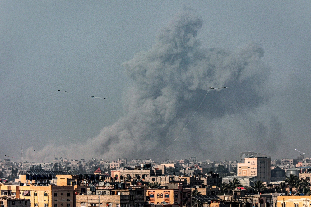 Kites fly in Rafah as a smoke plume erupts during Israeli bombardment on Khan Yunis in the southern Gaza Strip on March 29, 2024, amid ongoing battles between Israel and the Palestinian group Hamas. — AFP pic