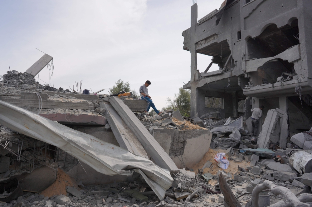 A Palestinian youth inspects the debris of a building, following Israeli bombardment, in the Maghazi camp for Palestinian refugees in the central Gaza Strip on March 29, 2024, amid the ongoing conflict in Gaza between Israel and the Palestinian group Hamas. — AFP pic