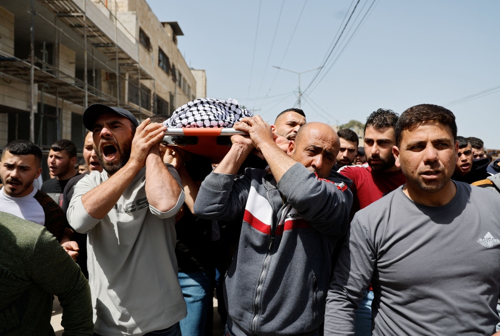 Mourners carry the body of Palestinian teen Mutasem Kameel, 13, who was killed in an Israeli raid, during his funeral near Jenin, in the Israeli-occupied West Bank March 30, 2024. — Reuters pic  