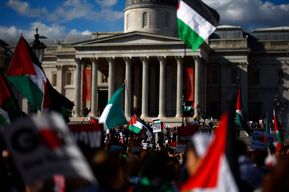 Pro-Palestinian activists and supporters wave flags as they gather for a protest in Trafalgar Square in central London on March 31, 2024, calling for a ceasefire in the Israel/Palestine conflict. — AFP pic
