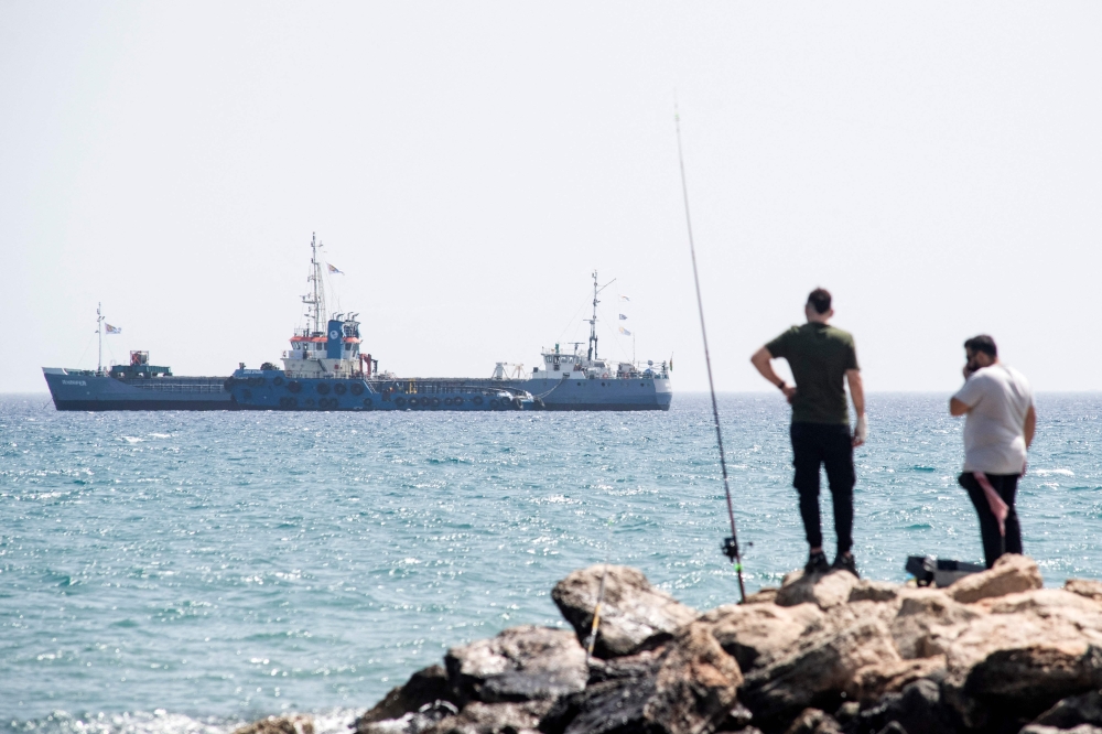 A Cyprus Coast Guard patrol boat approaches the Guinea-Bissau-flagged cargo ship Jennifer, carrying food aid provided by US charity World Central Kitchen (WCK) bound for the Gaza Strip, off the coast of Cyprus’ southern port city of Laranca on March 30, 2024 ahead of its departure with the second batch along the new assistance sea corridor to the besieged Palestinian territory. — AFP pic
