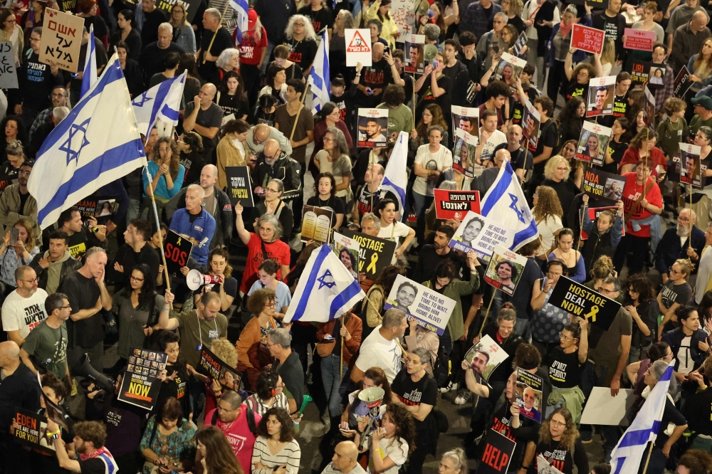 Protesters carry placards during a gathering by relatives of Israeli hostages held in Gaza since the October 7 attacks by Hamas militants, in front of the Defence Ministry in the Israeli coastal city of Tel Aviv, on March 30, 2024, amid the ongoing conflict in the Gaza Strip between Israel and the Palestinian militant Hamas movement. — AFP pic