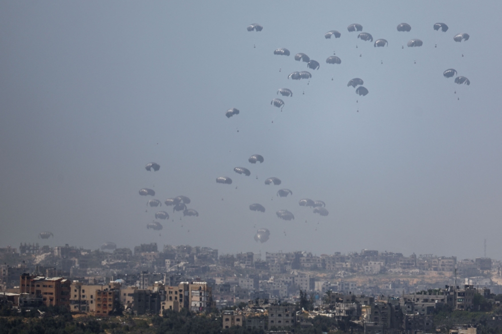Humanitarian aid falls through the sky towards the Gaza Strip after being dropped from an aircraft, amid the ongoing conflict between Israel and the Palestinian Islamist group Hamas, as seen from Israel, March 31, 2024. — Reuters pic