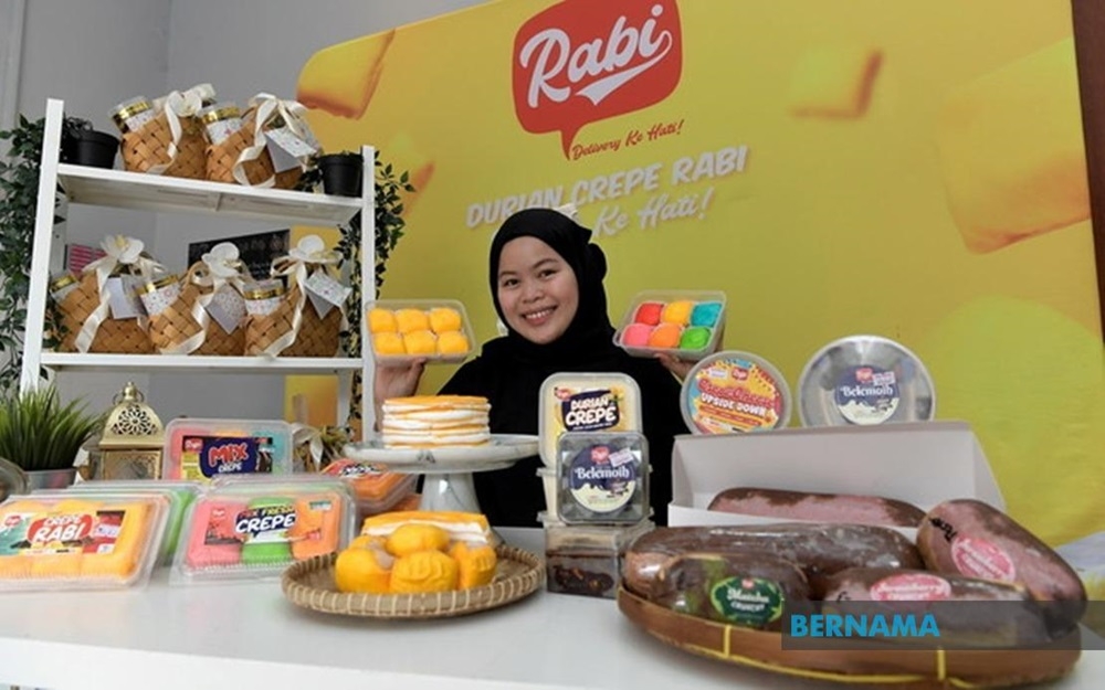 Durian Crepe Rabi founder Robiatul Adawiah Ibrahim poses with her products. — Picture via X/Bernama 