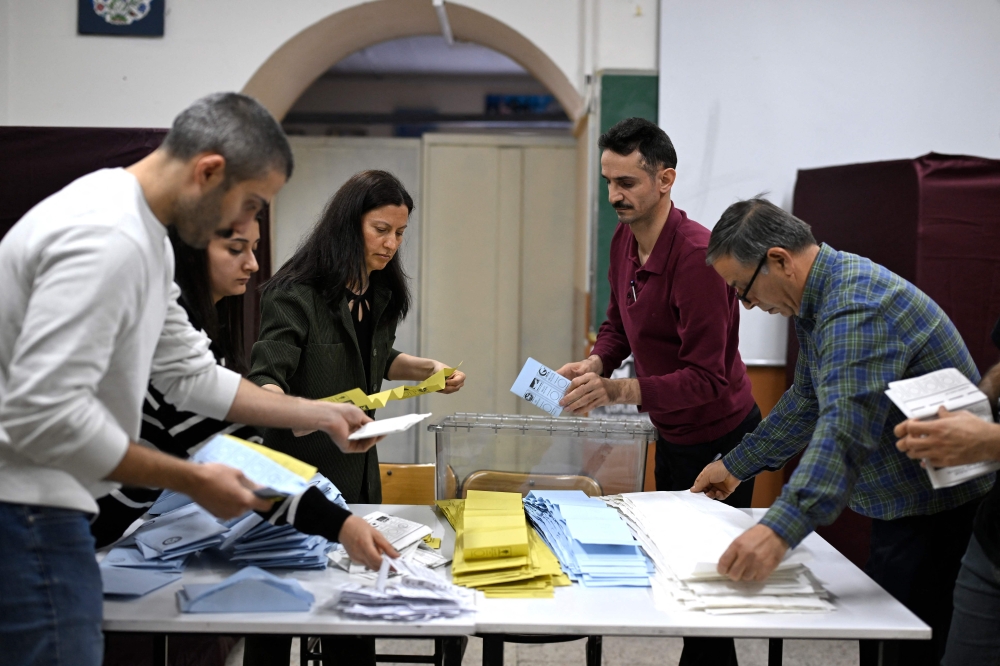 Electoral workers begin to count ballots at a polling station following municipal elections across Turkey, in Istanbul on March 31, 2024. — AFP pic