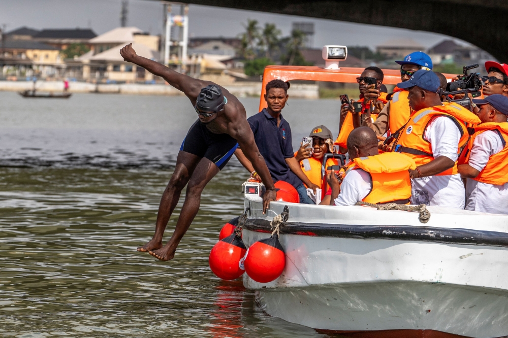Akinrodoye Samuel jumps into the water, to start his ambitious endeavor to swim the 11.8 km stretch of the Third Mainland Bridge, advocating for the theme 'Swim Against Suicide And Depression' in Lagos, Nigeria, March 30, 2024. — Reuters pic  