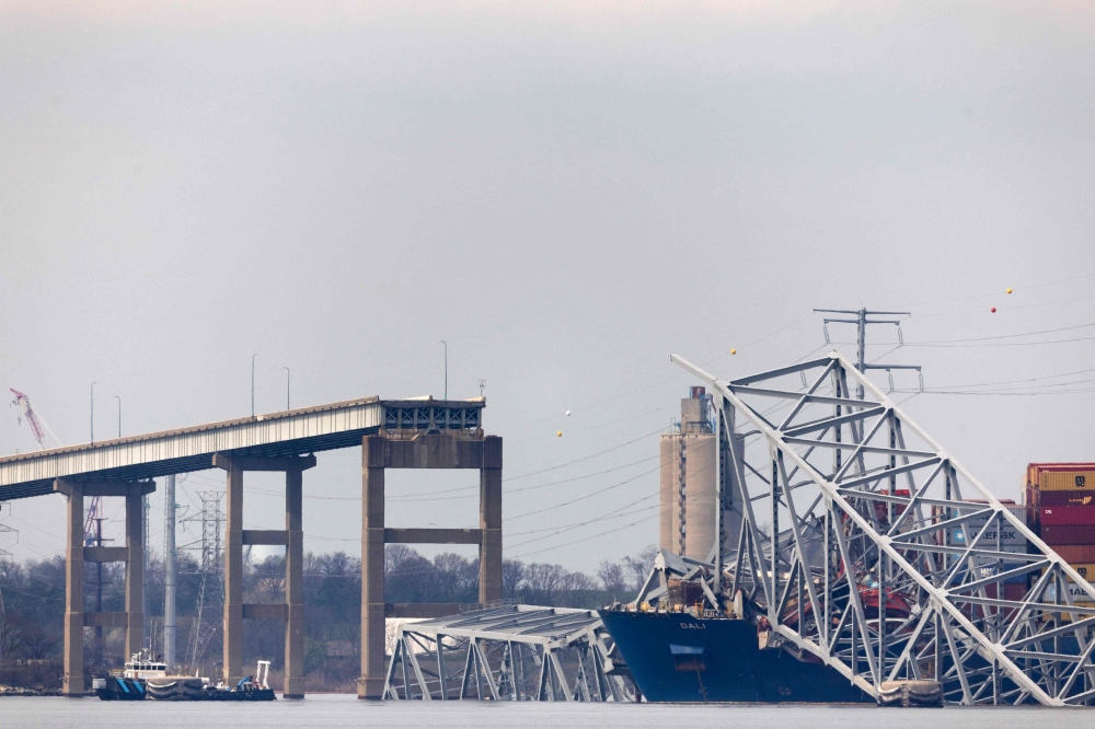 Debris is cleared from the collapsed Francis Scott Key Bridge as efforts begin to reopen the port. — AFP pic