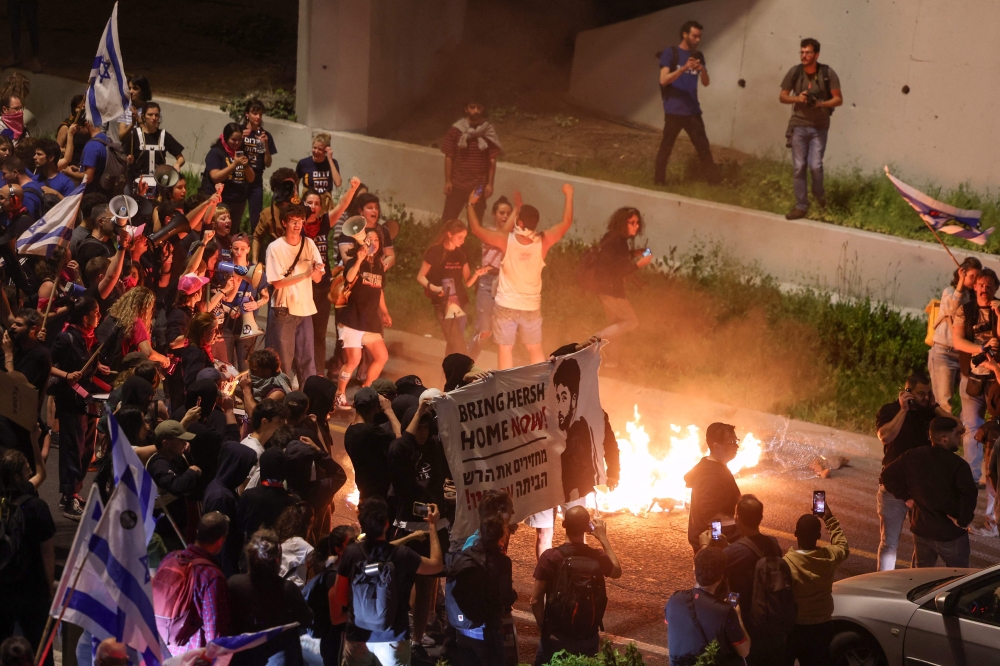 Demonstrators blocked a main city highway after earlier rallying in front of the Israeli parliament, lighting fires and waving Israeli flags. — AFP pic
