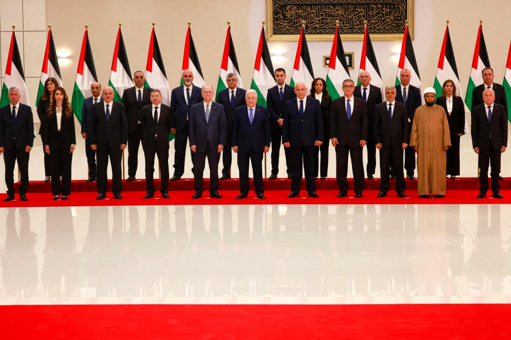 A new Palestinian government that contains both Gazans and four women was sworn yesterday, but was already facing scepticism from its own people. — AFP pic