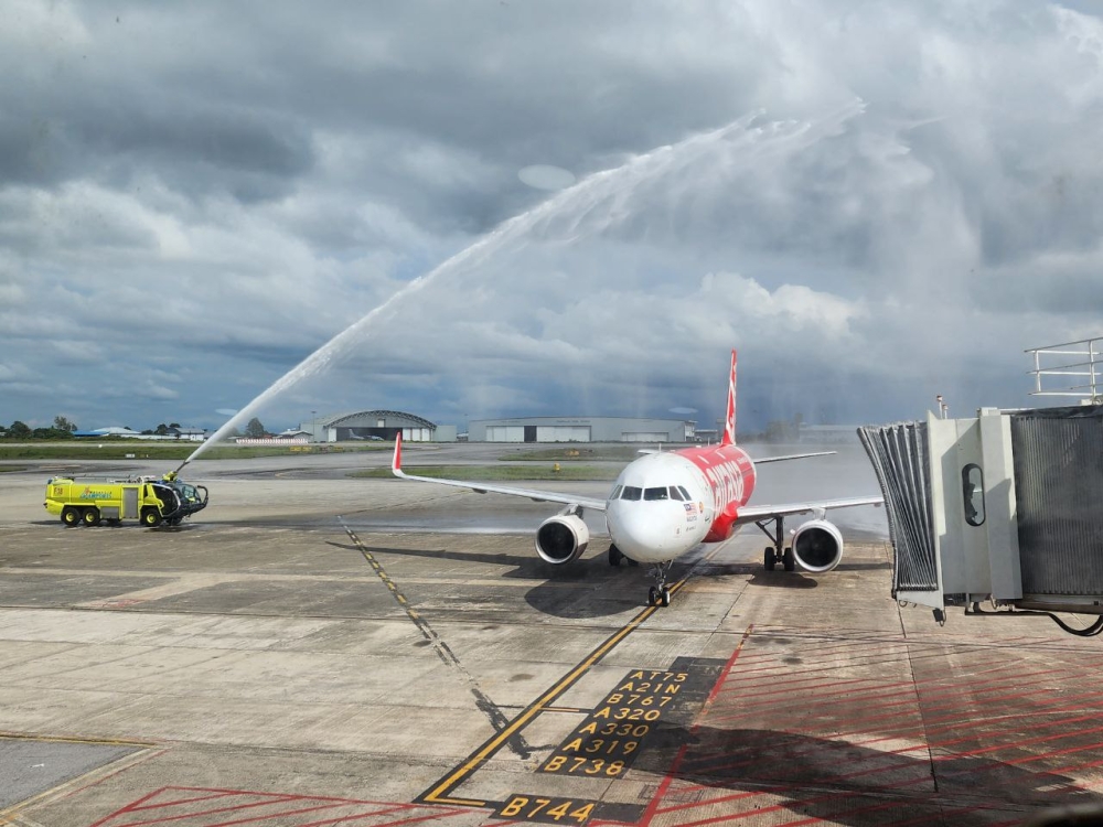 The AK5432 aircraft from Penang gets a water salute welcome upon arrival at the KIA. — The Borneo Post pic