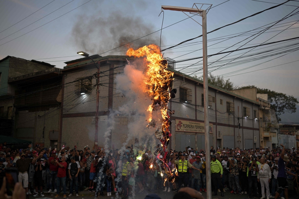 Venezuelans burned dummies representing President Nicolas Maduro or opposition presidential hopefuls — depending on their politics — as they honoured an Easter Sunday tradition. — AFP pic