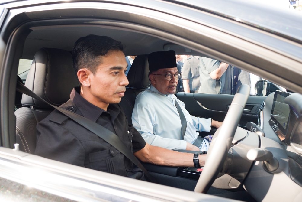 Prime Minister Datuk Seri Anwar Ibrahim (right) takes a ride in a hydrogen fuel cell vehicle, during a demonstration of the car in Putrajaya April 1, 2024. — Picture by Miera Zulyana